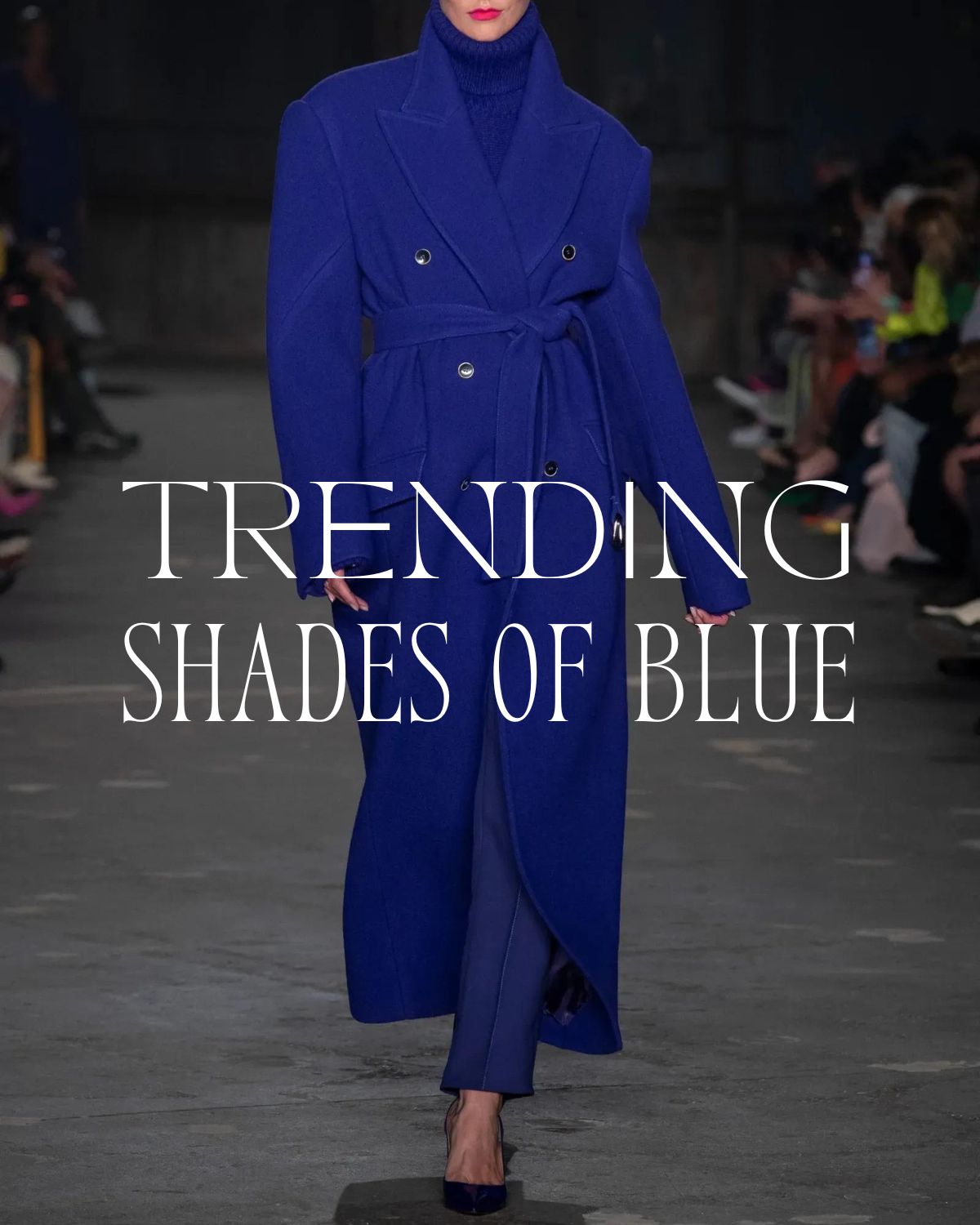  A super model walking down the runway in a blue coat and trousers