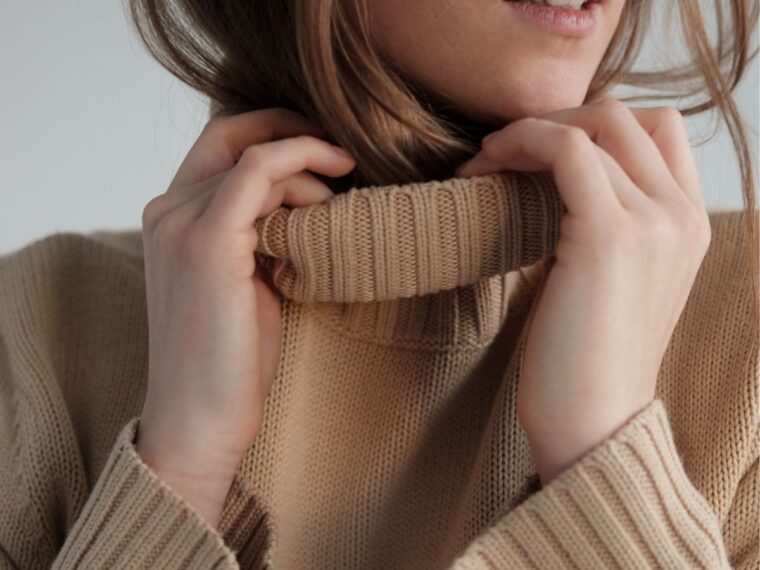 Girl holding brown turtleneck sweater