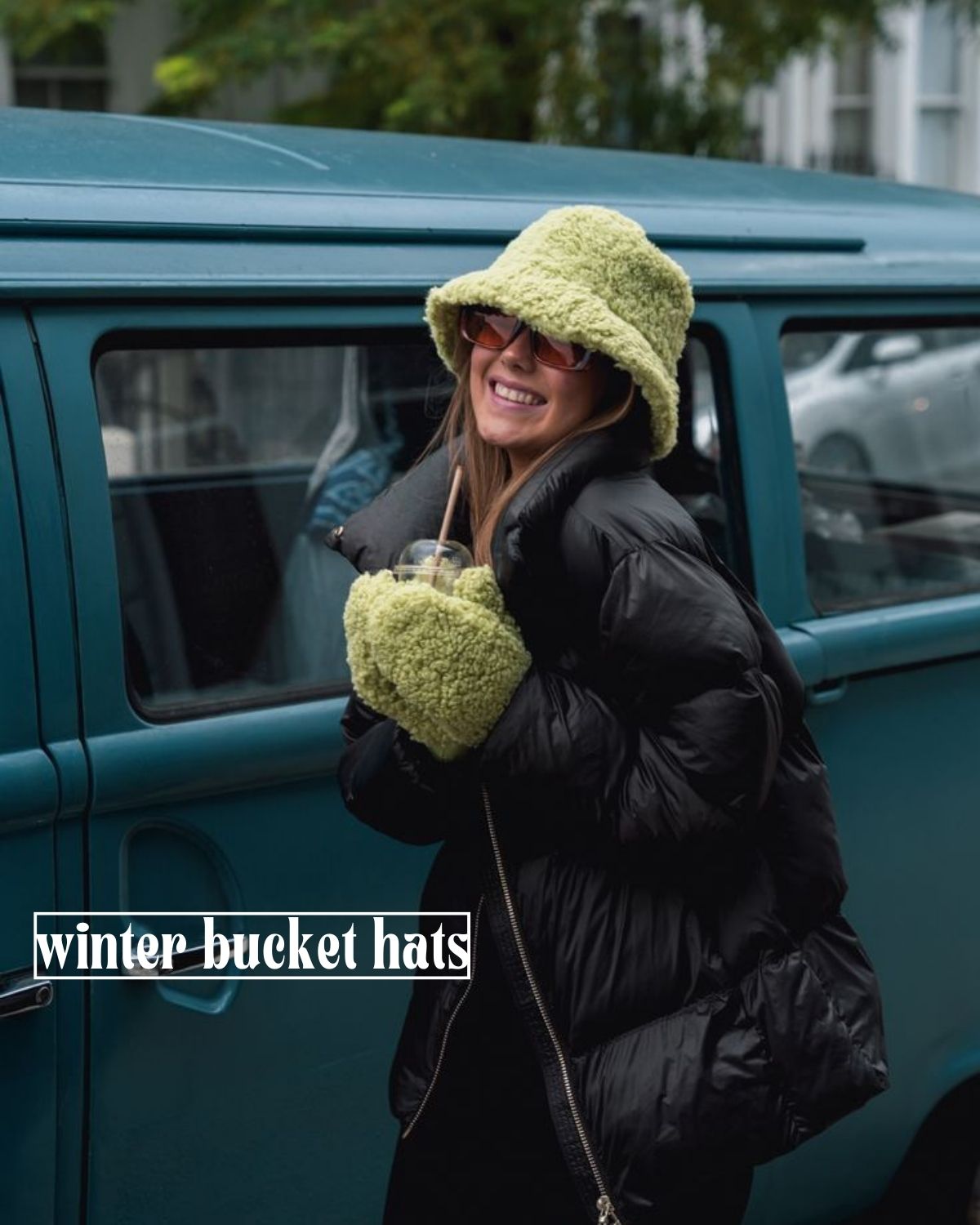 Girl in a cute green and black winter outfit in a teddy bucket hat and mittens