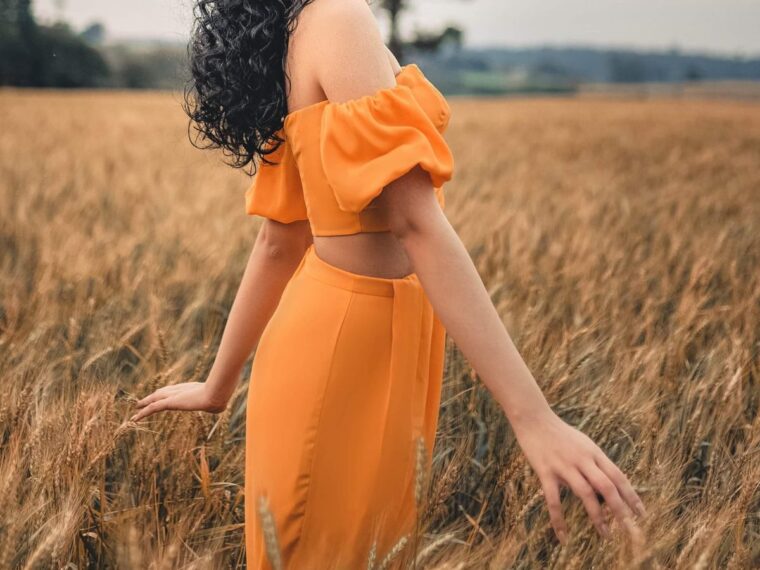 girl in a field in an orange dress