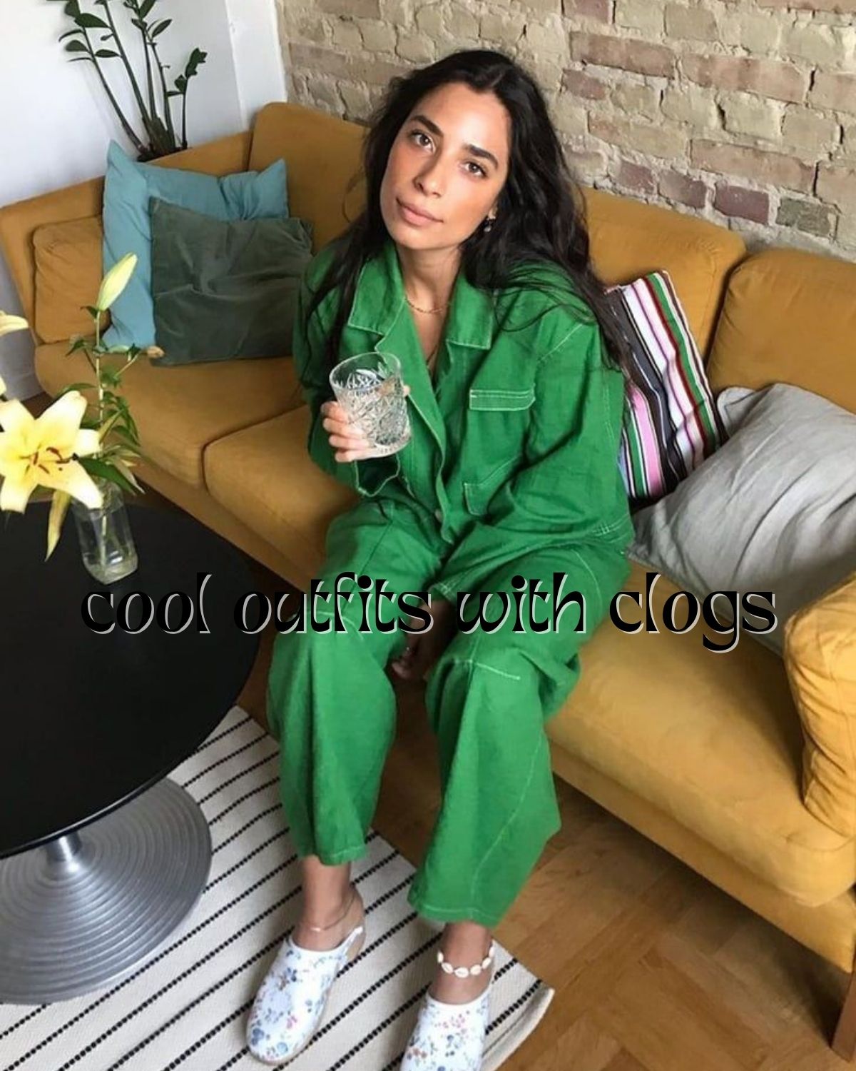 A girl in a green suiting with floral clogs, sitting on a couch