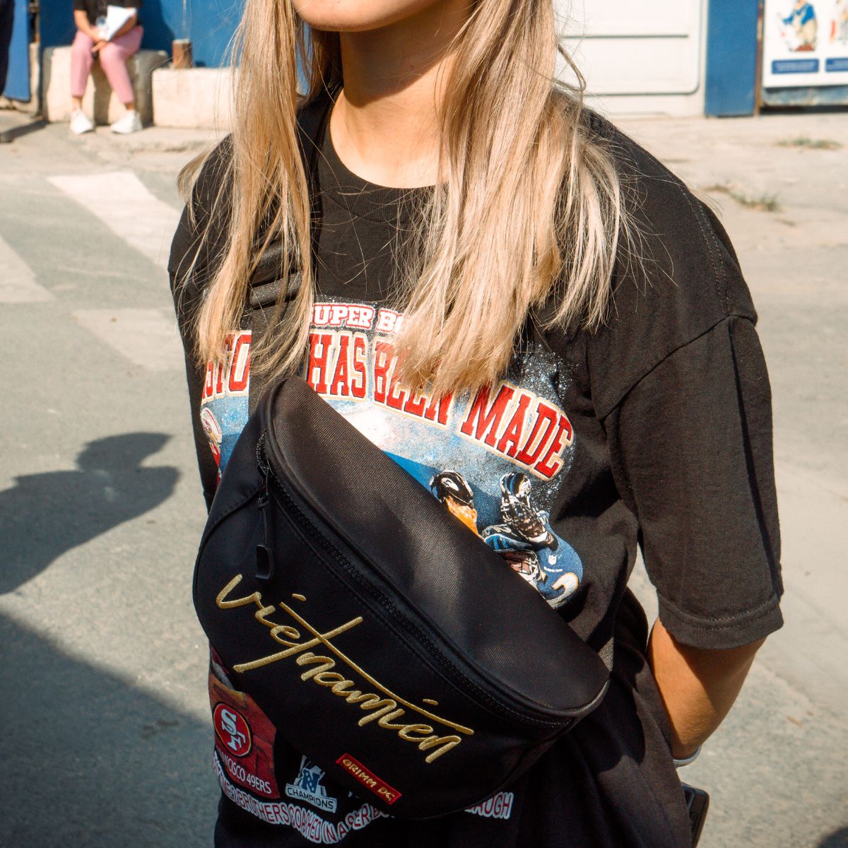 Girl wearing a graphic tee with a belt bag across her chest