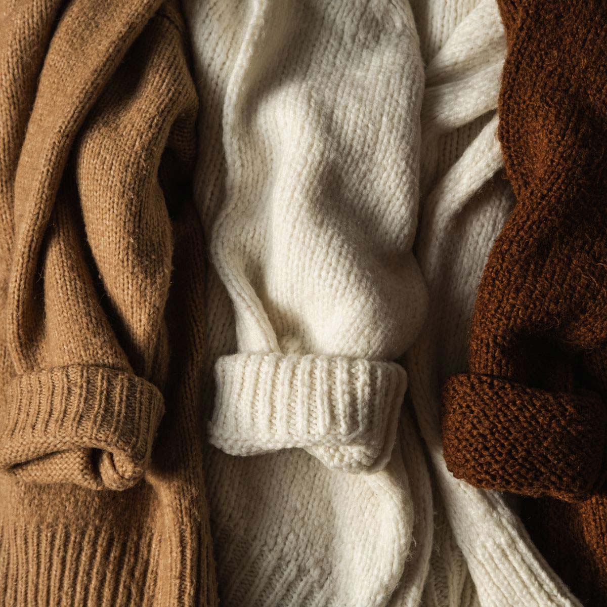 Photo of 3 different neutral sweaters.