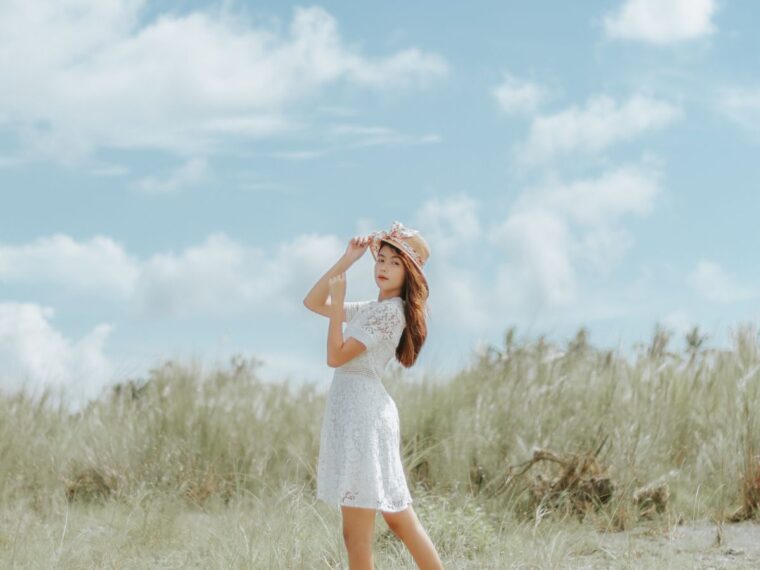 A girl in a field wearing a white dress
