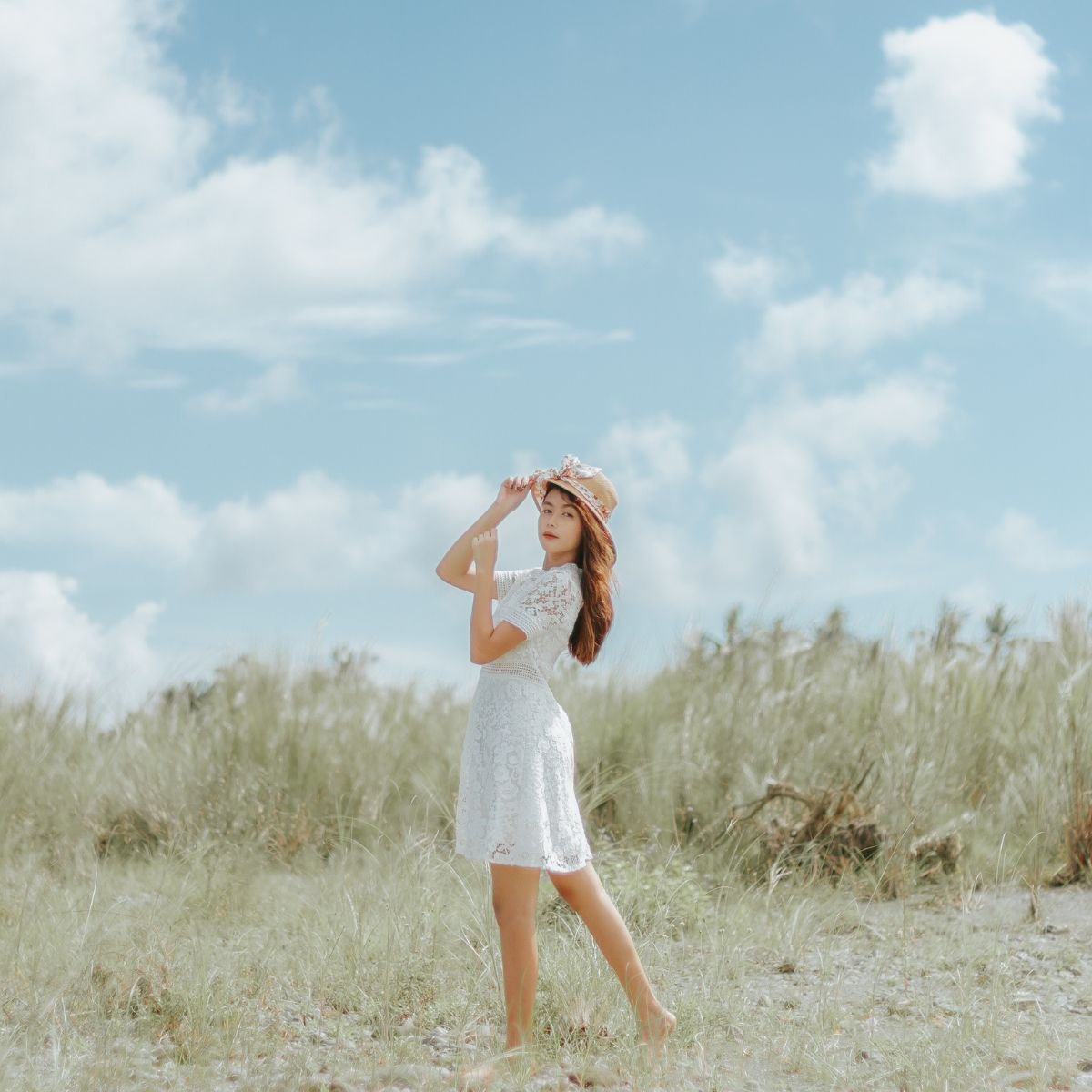 A girl in a field wearing a white dress