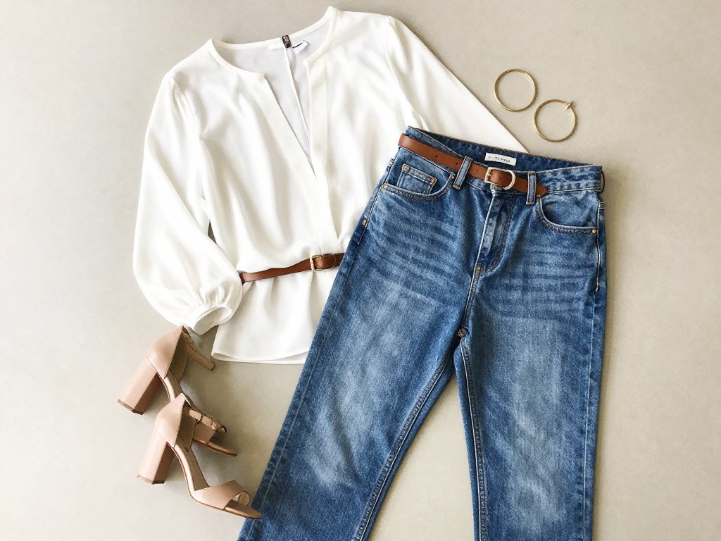 high-waisted jeans styled with tucked blouse and belt