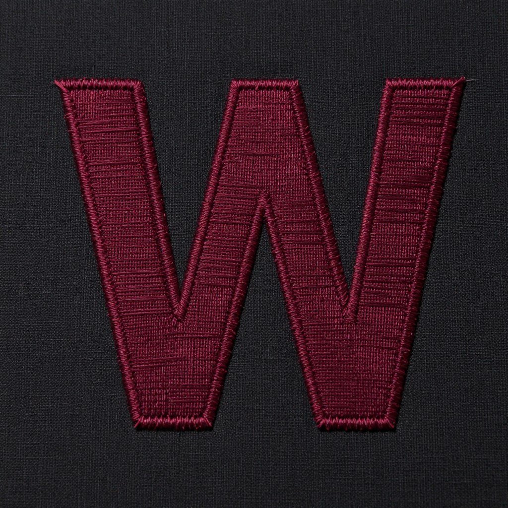 Creative negative space hand embroidery letters where background is filled leaving letter shapes empty on dark fabric