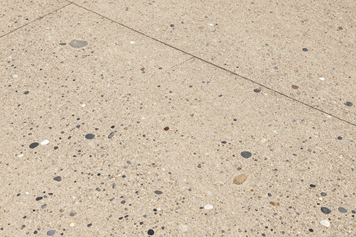 Exposed aggregate concrete patio showing decorative stones in natural tones