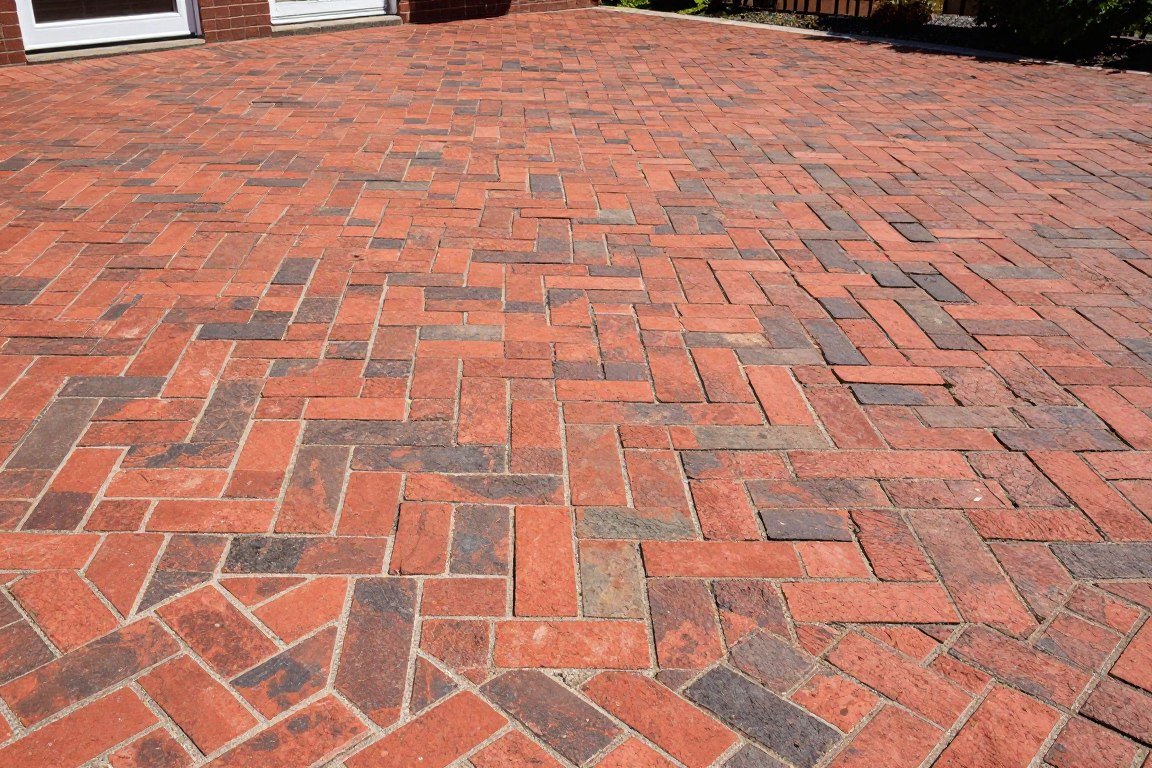 Herringbone pattern stamped concrete patio in classic brick red with diagonal layout