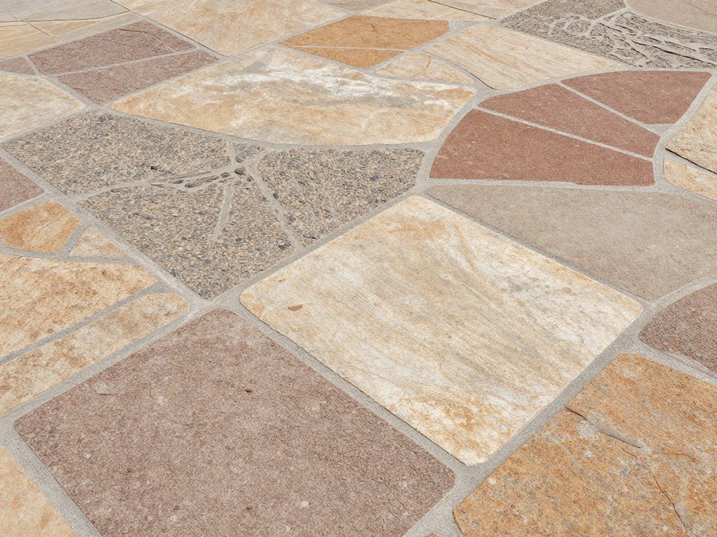 Multi-pattern stamped concrete combining different stone textures in varied earth tones