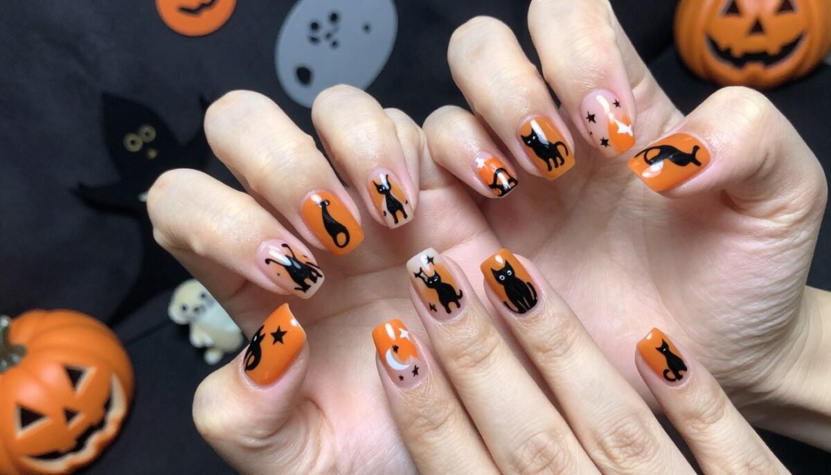 October nails featuring black cat silhouettes on orange background for spooky season October nails featuring black cat silhouettes on orange background for spooky season