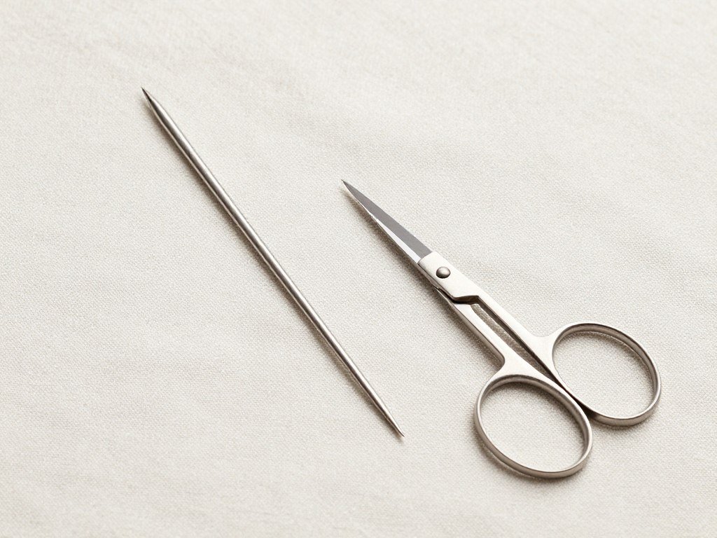 Yarn needle and scissors on fabric background