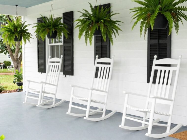 charming farmhouse front porch with white rocking chairs and hanging ferns