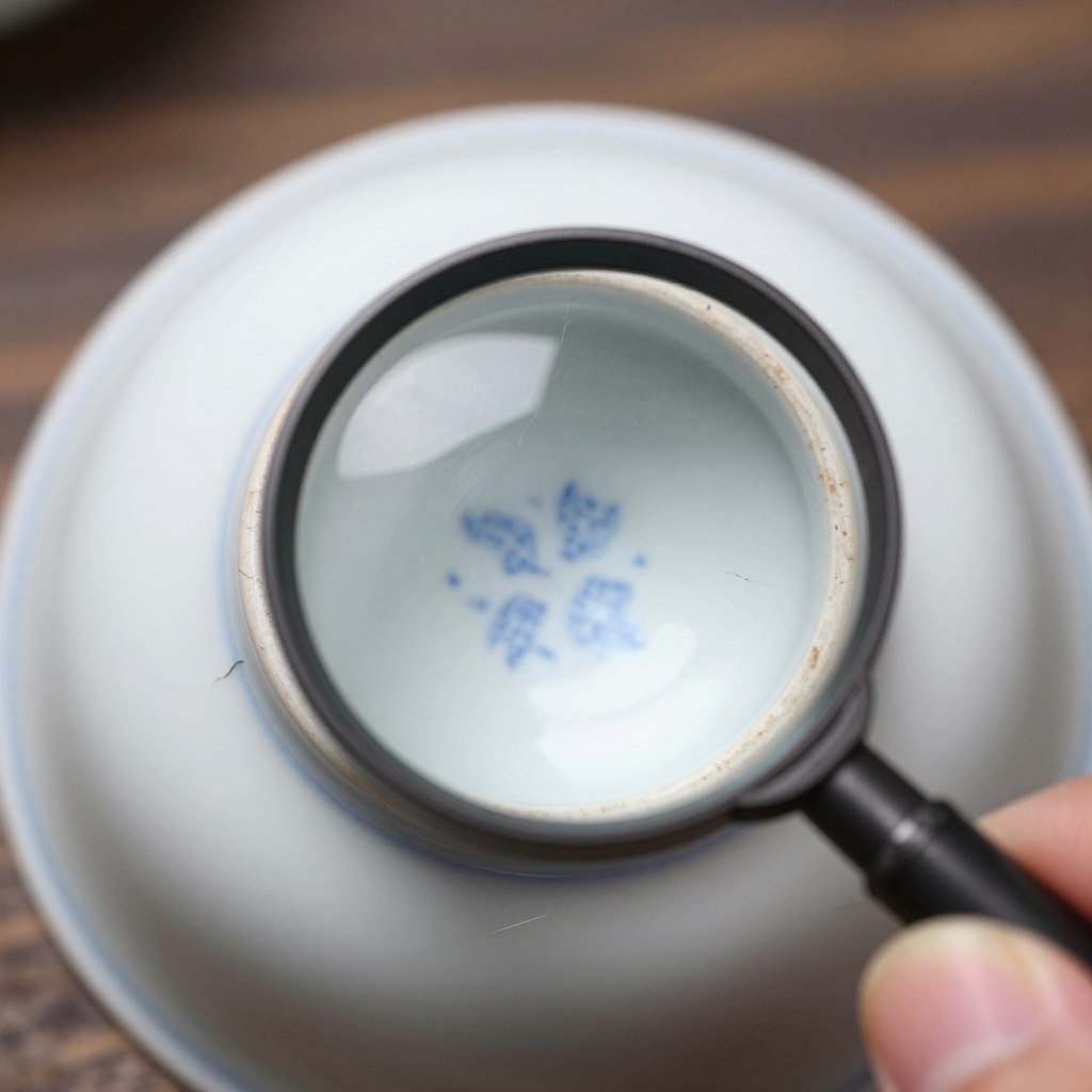 close inspection of tea cup for cracks with magnifying glass