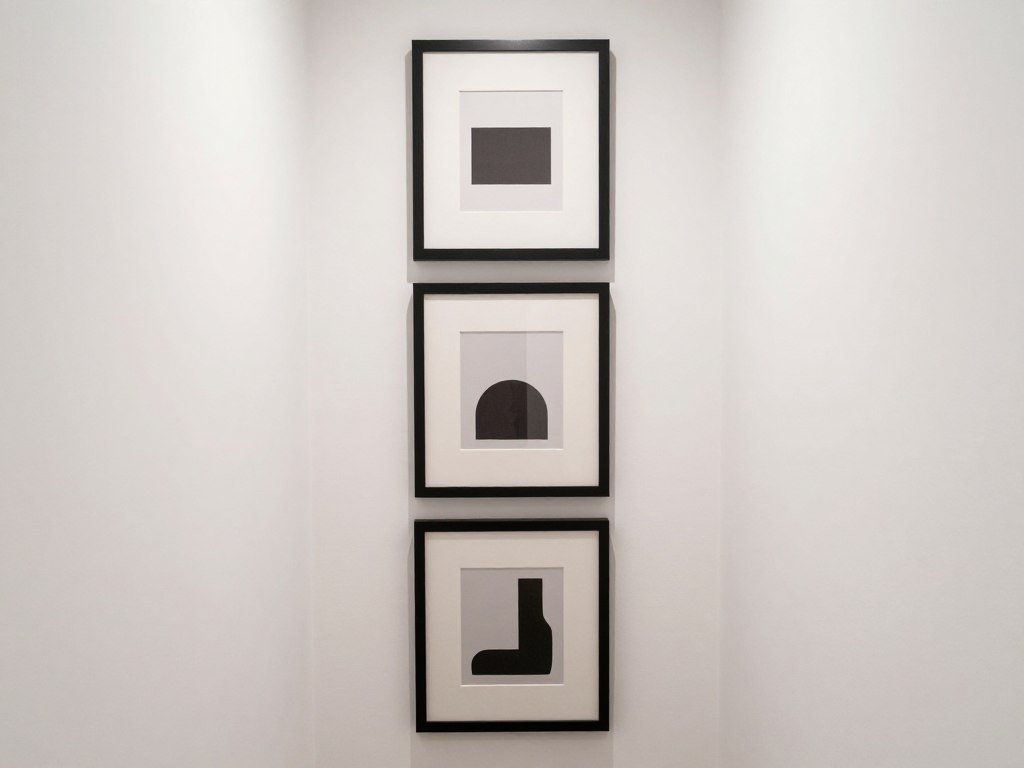 vertical wall art arrangement in narrow hallway