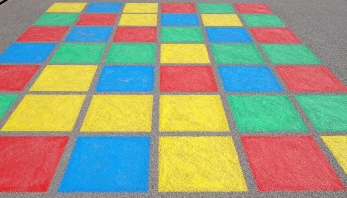 Grid of colored squares in red, blue, yellow, and green on pavement Grid of colored squares in red, blue, yellow, and green on pavement