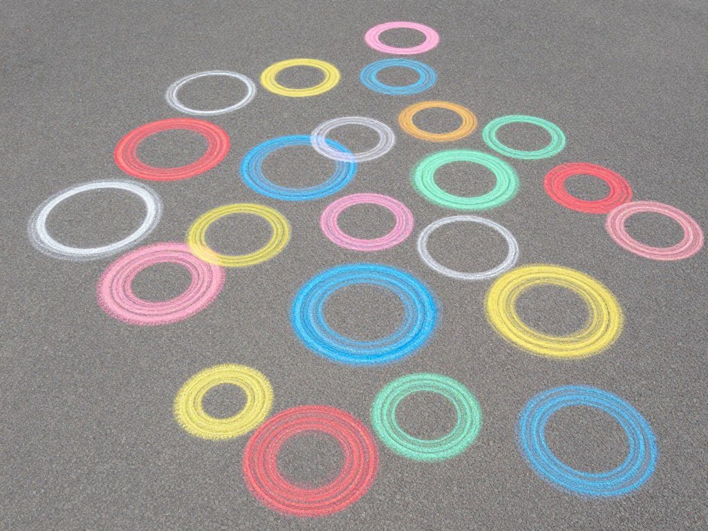 Multiple colored circles of different sizes drawn in chalk for jumping game