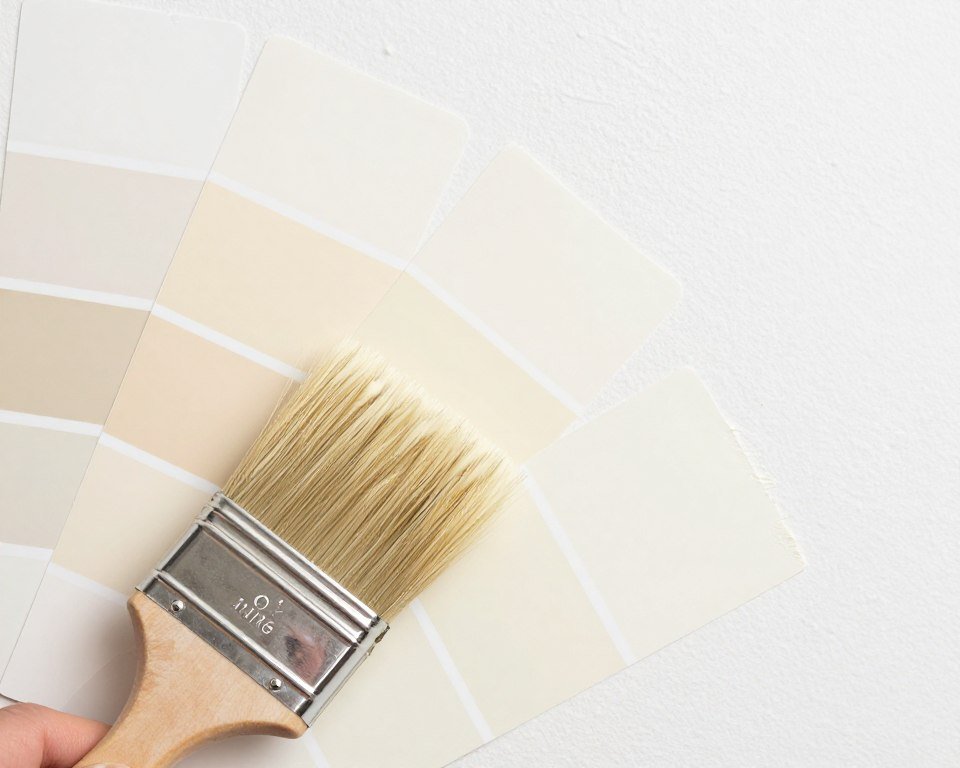 Paint samples of various cream tones on bedroom wall