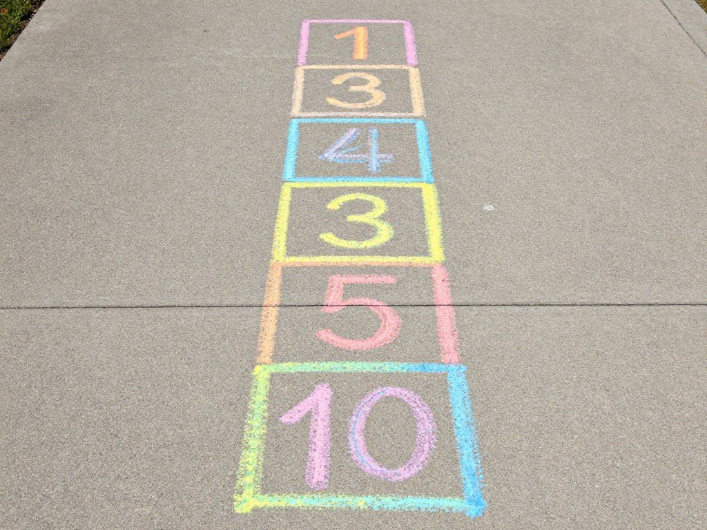 Traditional hopscotch pattern drawn in bright chalk on concrete